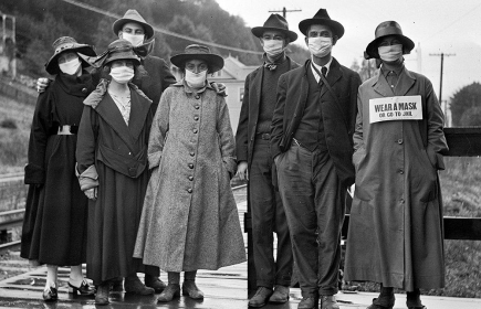 Port du masque au temps de la grippe dite espagnole Mill Valley, Californie, 1918. Sur la pancarte portée par la femme à droite : « Portez un masque ou vous irez en prison ».
